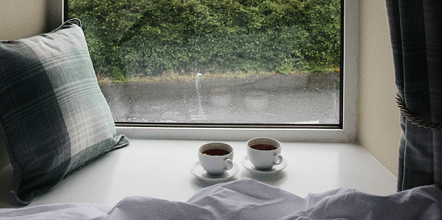 Foto di finestra di fronte a due tazze di té della Living srl Living serramenti